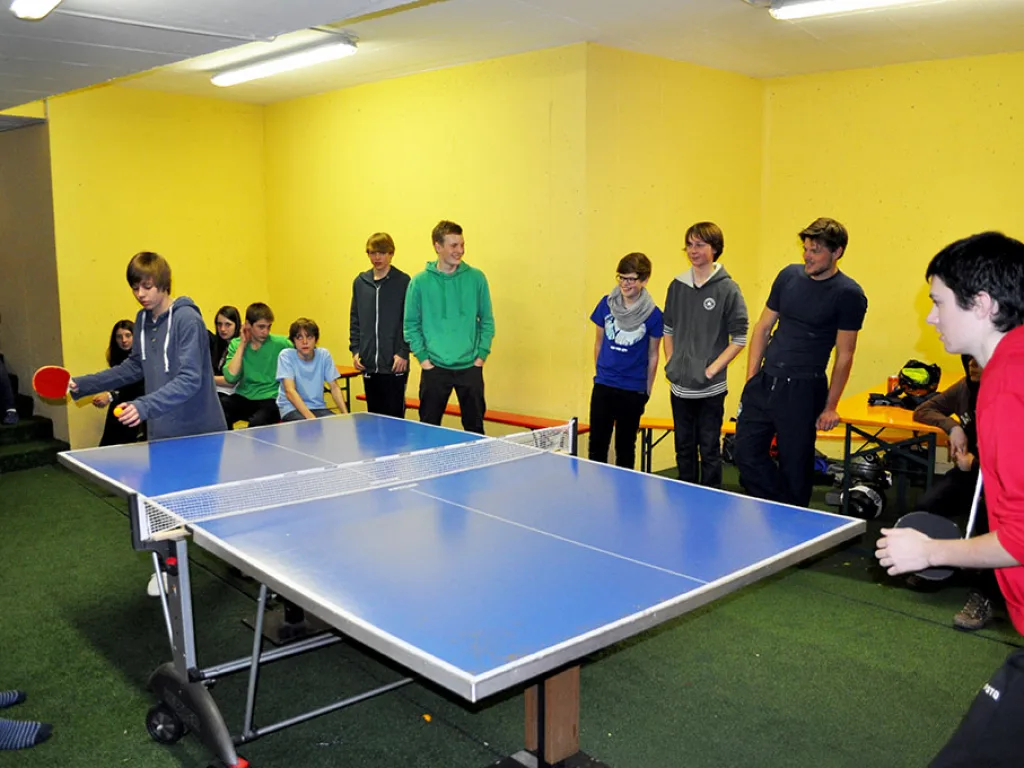 Jugendliche spielen Tischtennis im Aufenthaltsraum.